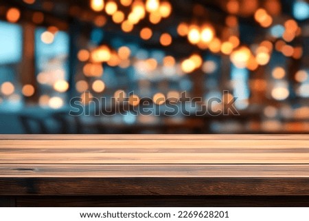 Empty wooden table in front of blurred cafe bar or restaurant. Abstract lights bokeh background, front view, free space for your product. Royalty-Free Stock Photo #2269628201