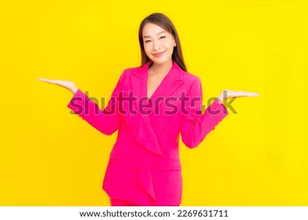 Portrait beautiful young asian woman smile in action on yellow color background