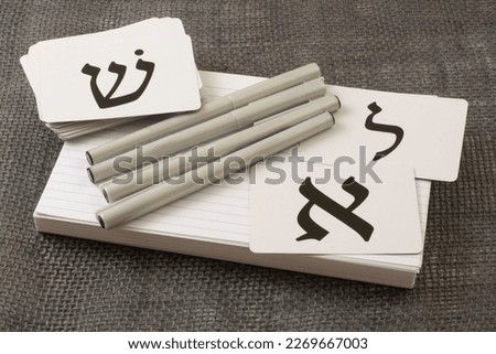 Tools for learning biblical Hebrew of index cards for vocabulary, calligraphy pens and alphabet flash cards: letters Aleph on right (A), Lamed (L) upper right, and Shin (sh sound) (upper left) Royalty-Free Stock Photo #2269667003
