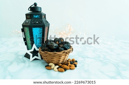 Eid and Ramadan concept with Turkish lamp Dates and dry fruits with fairy lights in background, selective focus