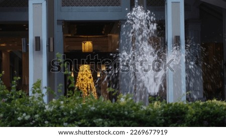 Christmas Tree Lights behind a blurred Water Fountain 