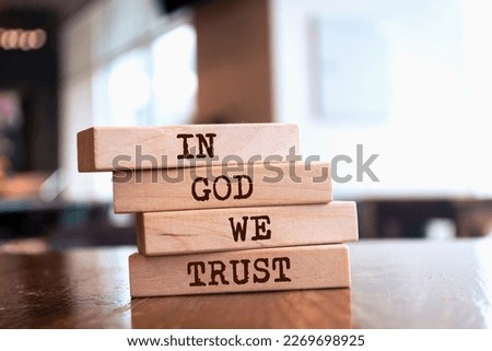 Wooden blocks with words 'In God We Trust'.