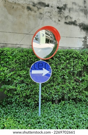 Blind corner mirror mounted and traffic signs on a posts Inside the building for parking.