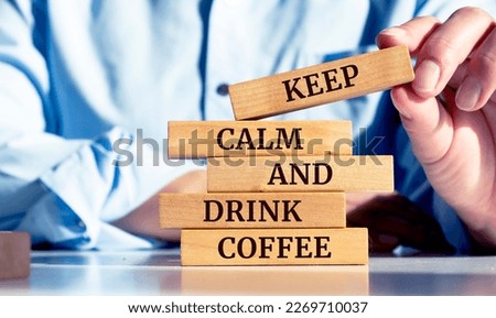 Close up on businessman holding a wooden block with "Keep Calm And Drink Coffee" message