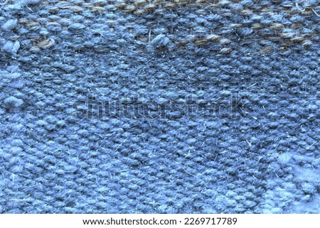 Woven blue wool fabric texture. Hand knitted textile canvas background. Patchwork carpet backdrop. Factory material threads. Abstract design. Close-up, mockup, top view