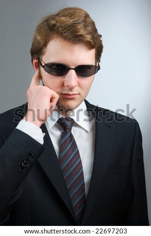 body guard or secret agent with serious expression on grey background
