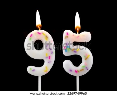 White decorated burning birthday candles on black background. Number 95. Royalty-Free Stock Photo #2269749965