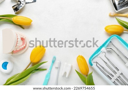 Frame made of dentist's tools and tulips on white background. Hello spring