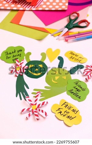 Child creating card and gift for best friend. Funny paper crafts