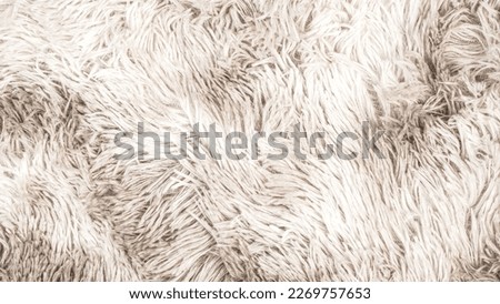 Background picture of a soft fur white carpet. 
wool sheep fleece closeup texture background. 
Fake color beige fur fabric. top view.