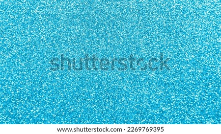 Blue color shiny Christmas texture background.
Abstract colour cyan glitter poster with blinking lights. 
 top view.