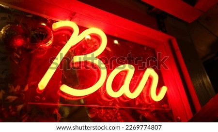 Bar fluorescent sign Light glowing at night in entrance door. Red Bar advertising business glows in the dark