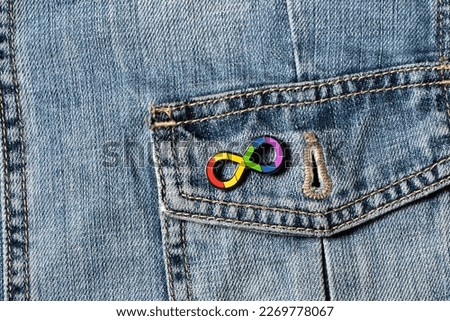 World autism awareness day. Closeup view of denim jacket with metallic pin brooch. Autism infinity rainbow symbol sign. Autism rights movement, neurodiversity, autistic acceptance movement symbol sign Royalty-Free Stock Photo #2269778067