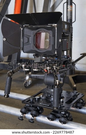 general view of a professional film camera, which stands on a camera trolley with wheels on rails