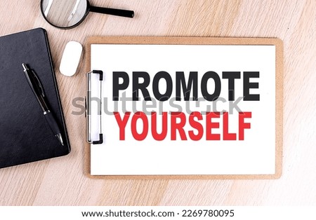 PROMOTE YOURSELF text on a clipboard on wooden background