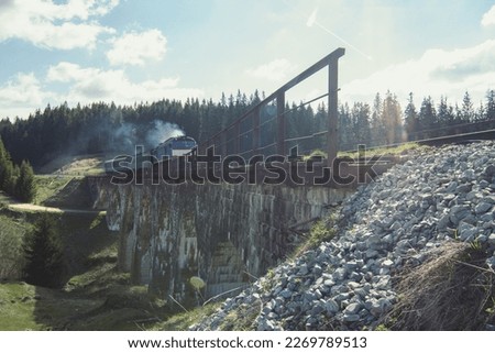 Train passing railway bridge near Carpathian forest landscape photo. Old railroad in mountains. Nature scenery photography. Ambient light. High quality picture for wallpaper, travel blog, magazine