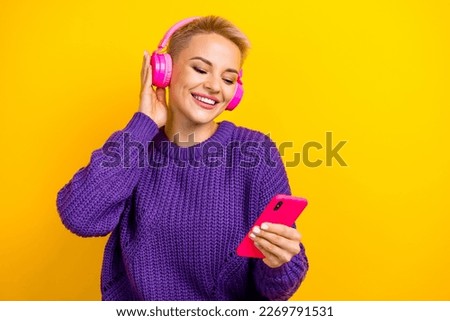 Photo of adorable pretty positive lady wear trendy clothes hold telephone use modern technology isolated on yellow color background