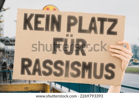 The phrase " No place for racism " is on a banner in men's hands with blurred background. Acceptance. Change. Transformation. Resistance. Opposition. Defiance. Protestor. Citizen. Activist. Democracy Royalty-Free Stock Photo #2269793393