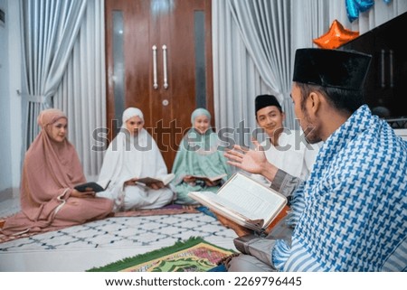 Recitation leader gives explanation while reading the Holy Quran during home recitation Royalty-Free Stock Photo #2269796445