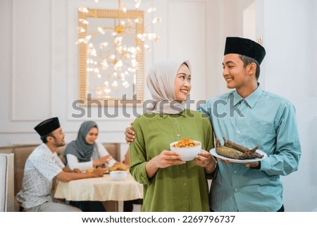 portrait of husband and wife serving food for friend and family for break fasting together during ramadan Royalty-Free Stock Photo #2269796737