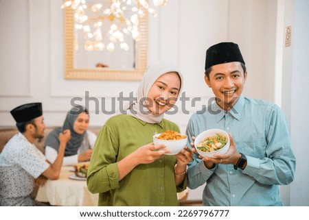 portrait of husband and wife serving food for friend and family for break fasting together during ramadan Royalty-Free Stock Photo #2269796777
