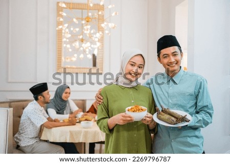 portrait of husband and wife serving food for friend and family for break fasting together during ramadan Royalty-Free Stock Photo #2269796787
