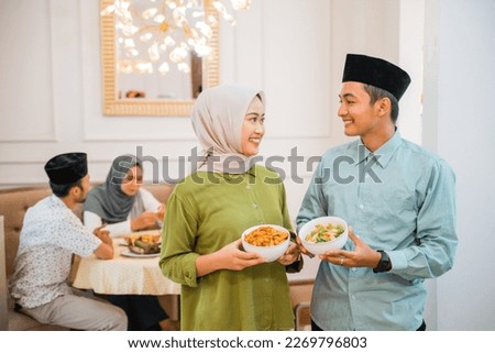 portrait of husband and wife serving food for friend and family for break fasting together during ramadan Royalty-Free Stock Photo #2269796803