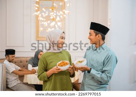 portrait of husband and wife serving food for friend and family for break fasting together during ramadan Royalty-Free Stock Photo #2269797015