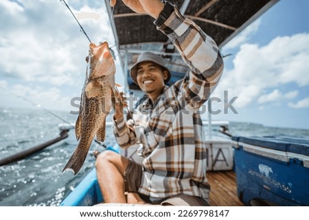 big grouper caught by an Asian angler with a fishing rod Royalty-Free Stock Photo #2269798147