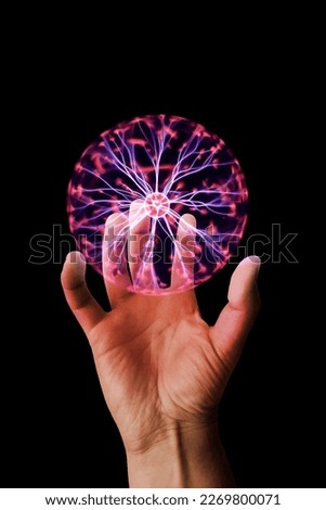 Close-up on a man's hand holding a plasmaball isolated on a black background. Royalty-Free Stock Photo #2269800071