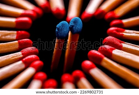 Red match heads are lined with a heart with two blue match heads inside. Matches close-up. Red and blue matches Royalty-Free Stock Photo #2269802731