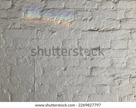 White brick wall texture with rainbow light. LGBT  symbol. Diversity society sign. Grunge background. Bricks image jpeg. LGBT+ rainbow colored. Freedom society concept. Street art on white wall.