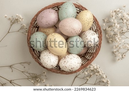 Banner. Easter frame with eggs and feathers on a blue wooden background. Minimal concept. View from above. Card with copy space for text.