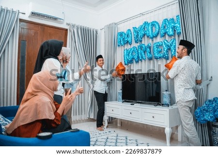 two men put up a sign for Ramadan celebration at home