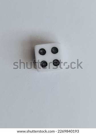 The white dice shows the number four.  White color photo background. 