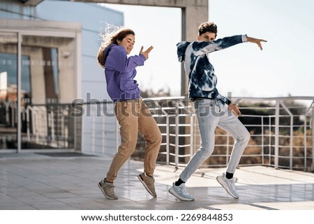 Stock photo of cool girl and her friend doing dance moves and having fun.