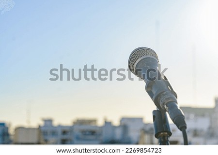 dynamic microphone on a tripod on the terrace of a building, concept of music, entertainment, music classes and sale of instruments. copy space
