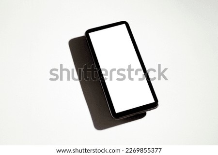 Smartphone with white screen on top of gray table. Cell phone concept. White screen concept.