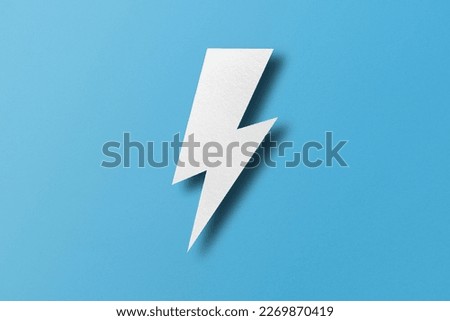 Paper cut lightning shape, lightning with light and shadow. Placed on a light blue paper background.