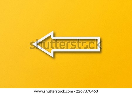 white paper arrow isolated on yellow paper background