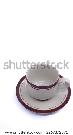 An empty cup and saucer isolated on a white background and illustrates fasting in the month of Ramadan.