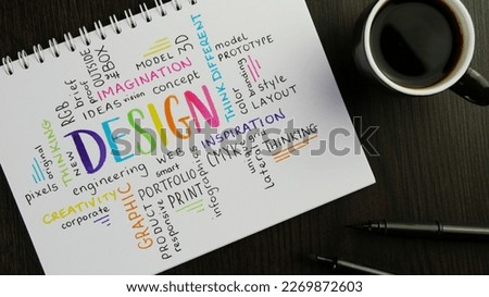 Colorful DESIGN word cloud handwritten in notebook with espresso and pens on black wooden desk Royalty-Free Stock Photo #2269872603