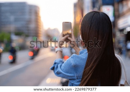 Woman take photo on the street in Taipei city