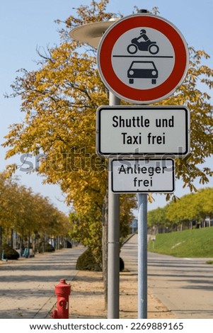Traffic sign with the German text "Shuttle und Taxi frei"