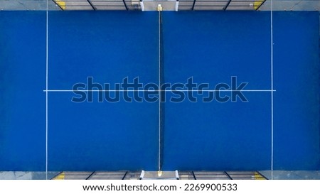 Perpendicular aerial view on a padel court. Characteristic blue flooring and glass that serve as walls. Closeup. Sports concept. Royalty-Free Stock Photo #2269900533
