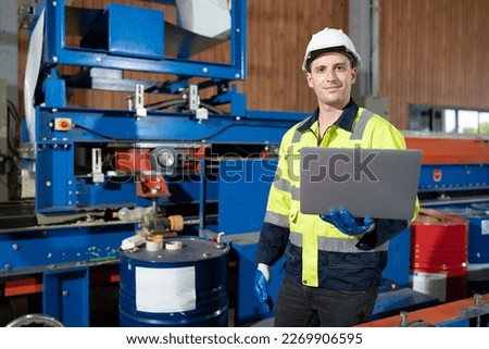 Portrait caucasian engineer man use notebook computer working and control machine at metal sheet factory	