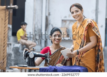 Indian woman using sewing machine at home.

