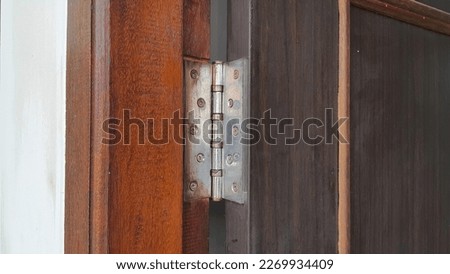 Stainless door hinges on wooden swing door. Door open. Royalty-Free Stock Photo #2269934409