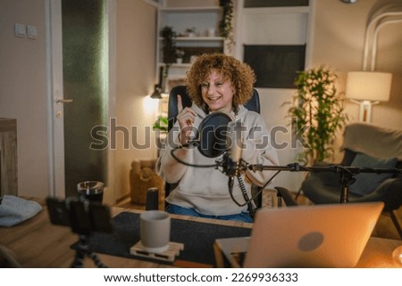 One woman caucasian female blogger or vlogger gesticulating while streaming video podcast in broadcasting studio use microphone and headphones famous influencer shooting video for channel podcast