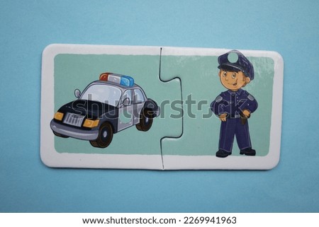 Colorful educational puzzle pieces with pictures of police and police cars placed on a blue background.